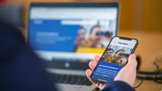 Mobiililaite ja tietokone, joissa on auki vantaan internet-sivut