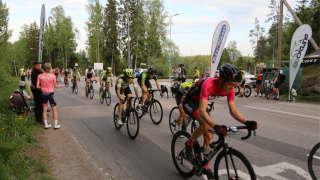 Maantiepyöräilijät polkemassa kadulla.