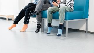 Three pupils are sitting on a couch inside the school.