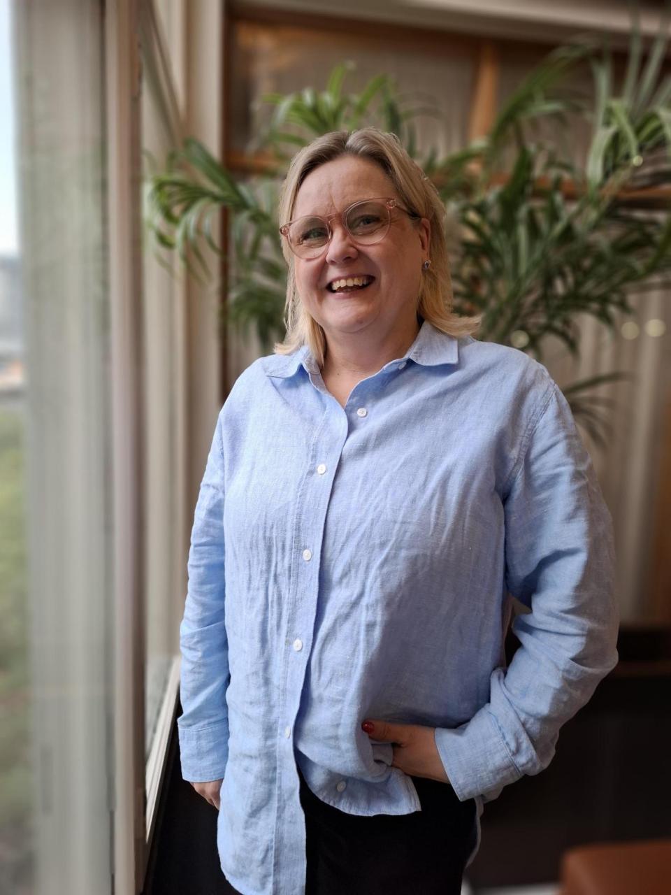 Työllisyyden ja kotoutumisen palvelualuejohtaja Susanna Taipale-Vuorinen Vantaan kaupungintalon aulassa hymyillen kameralle.